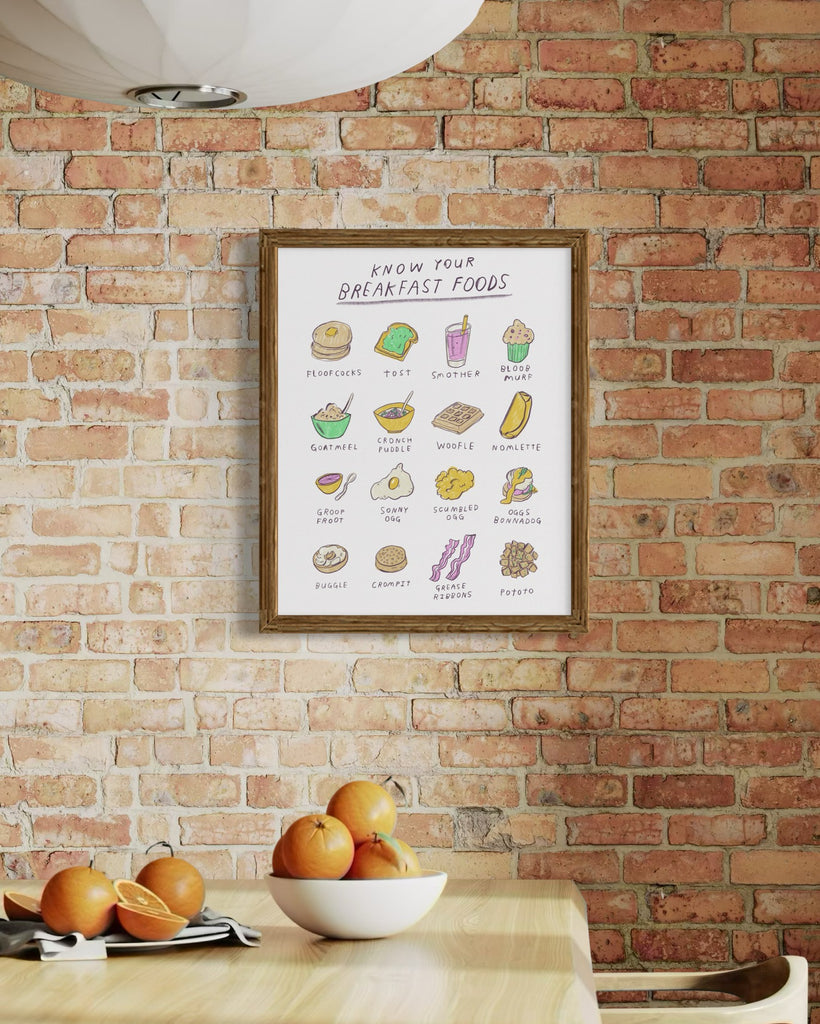 Poster of breakfast foods on a brick wall in a kitchen with oranges, illustrations art by Heather Buchanan 