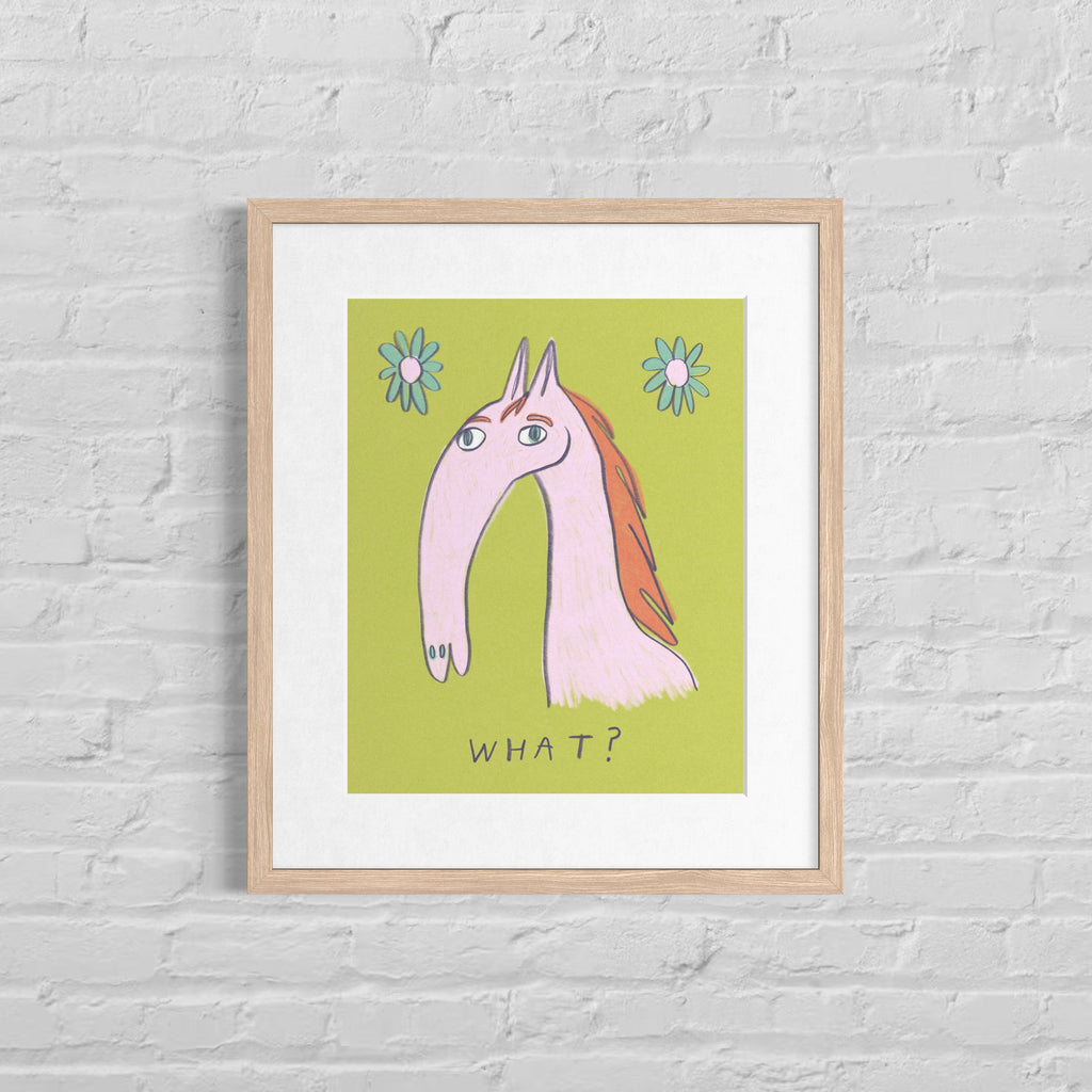 Framed illustration of a horse with flowers on a green background, text below that says “What?”, art hung on a white brick wall.